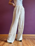 White linen-look trousers with elastic waist and lace drawstring